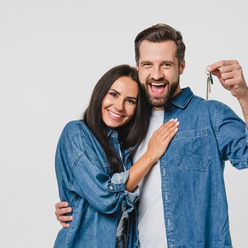 Homeowners. Happy young caucasian couple spouses wife and husband holding car house flat appartment keys, celebrating new purchase buying real estate isolated in white background. Mortgage loan